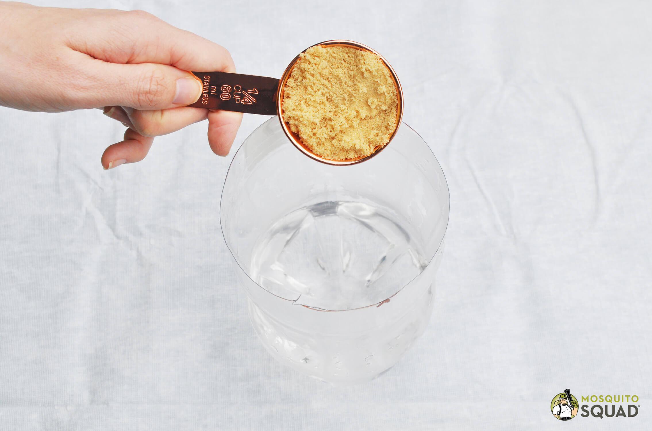 a quarter-cup of brown sugar going into a quarter cup of water