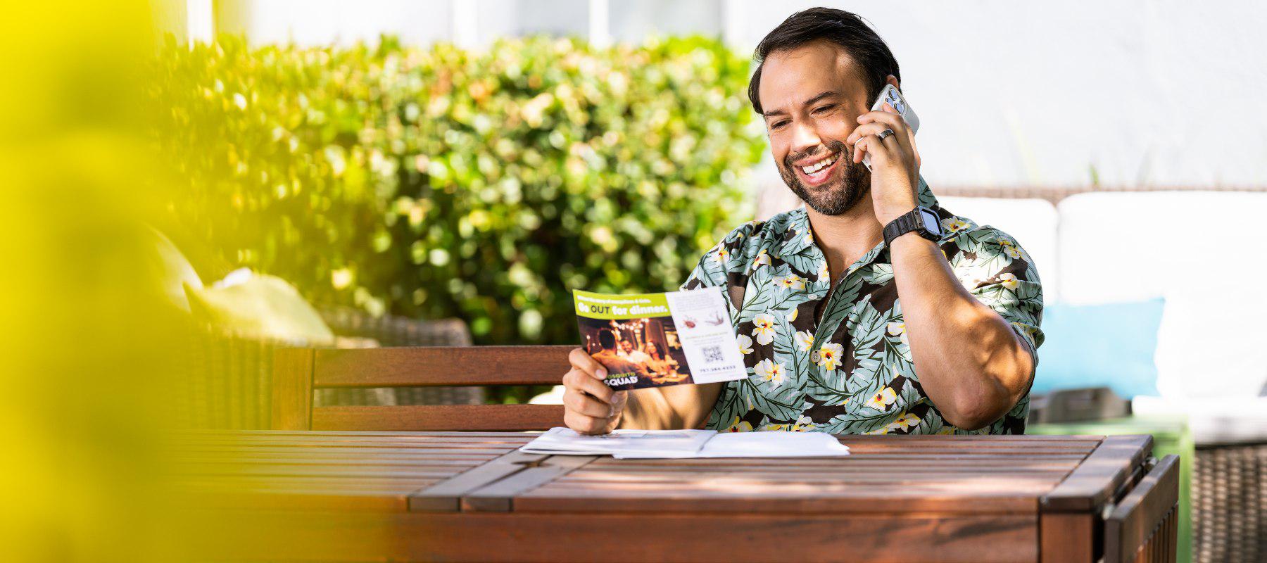 man on phone holding flyer