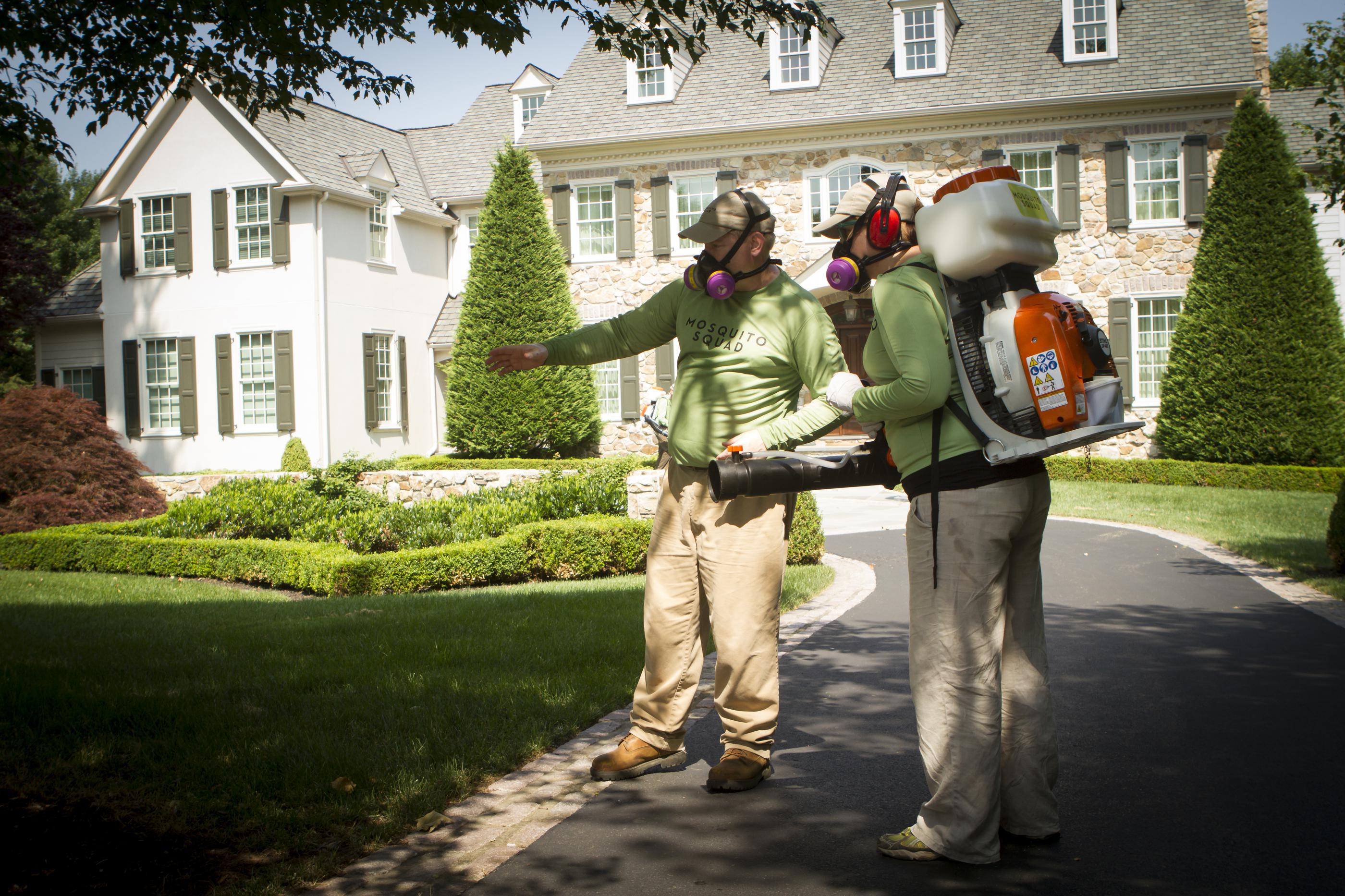 mosquito squad two men in front of house