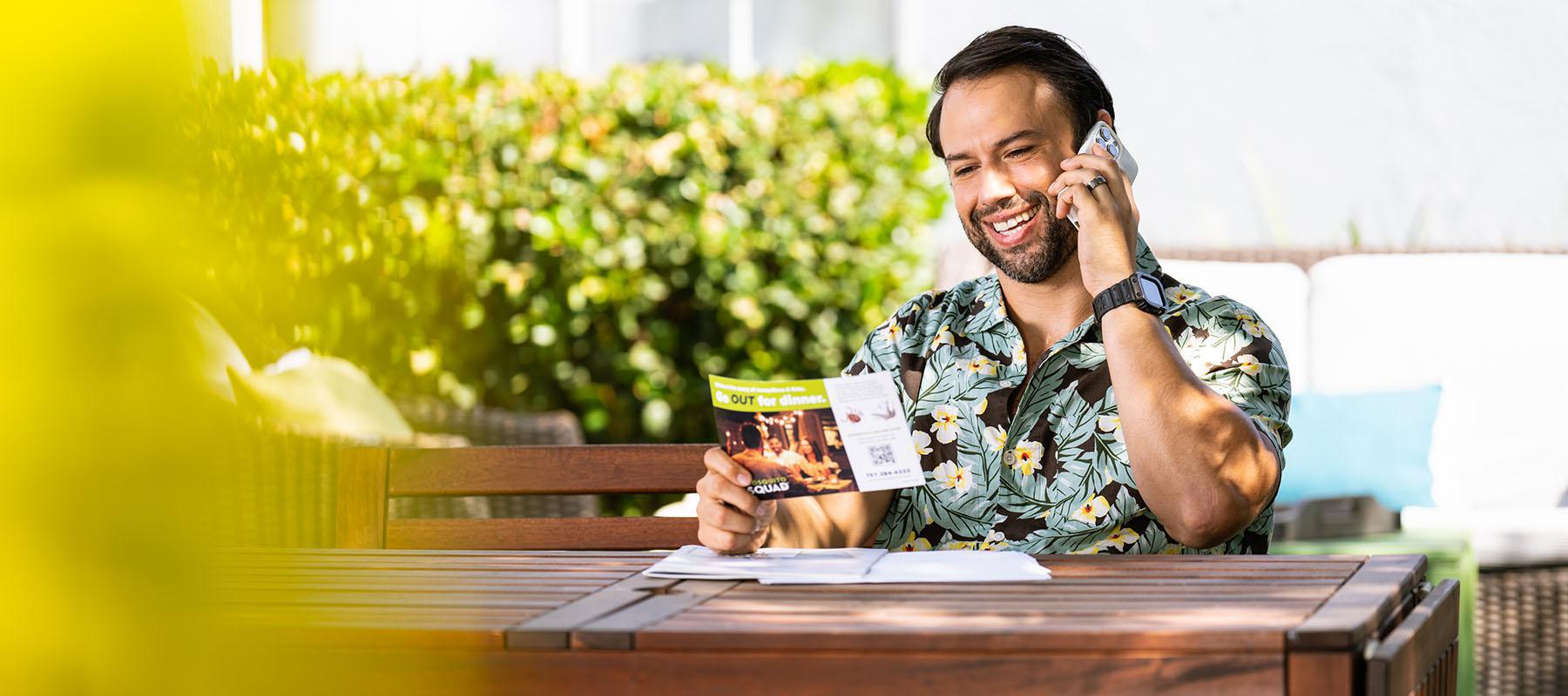 man on phone holding flyer