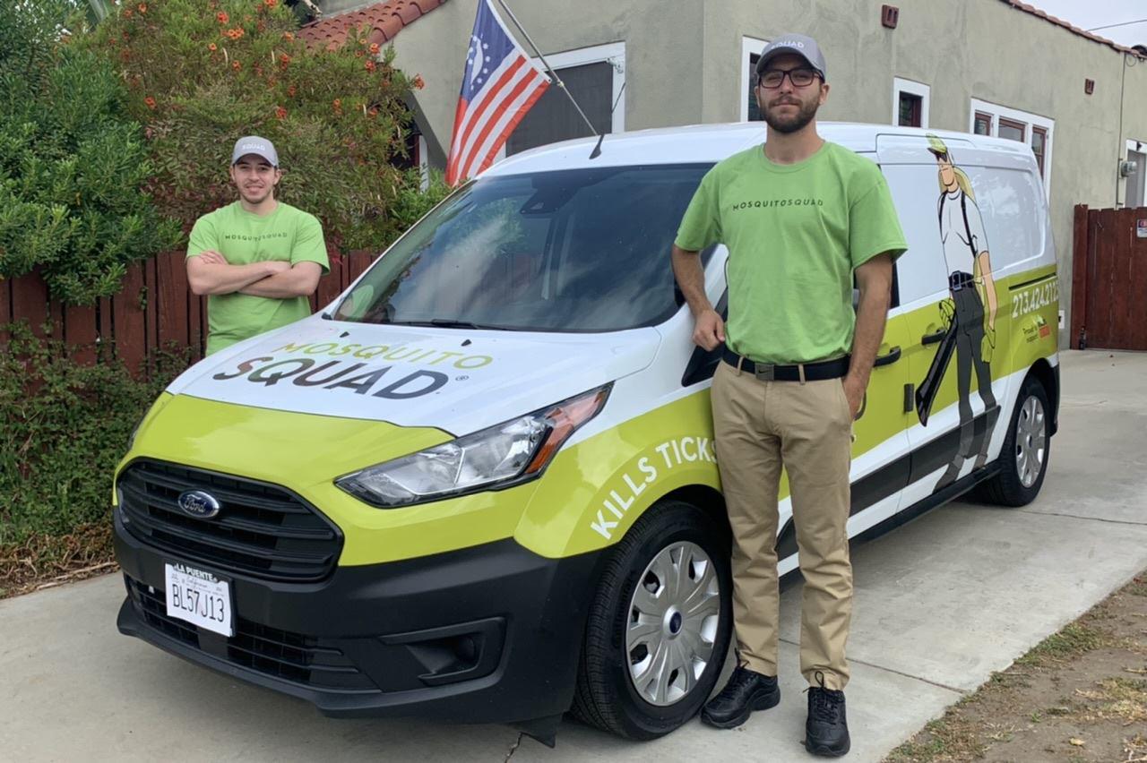 two technicians standing by mosquito squad truck