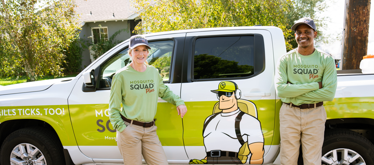 Two Mosquito Squad employees standing outside of a customer's house.